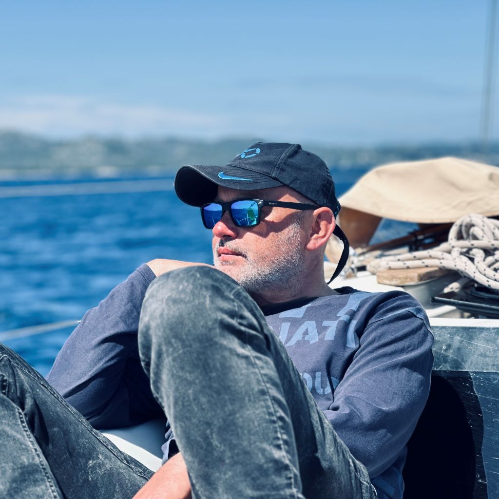 Instruktor żeglarstwa na płynącym jachcie, odpoczywający w kokpicie