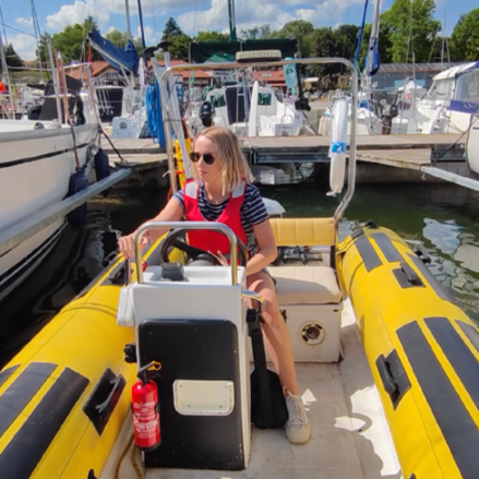 Dziewczyna manewrująca jachtem motorowym typu RIB w porcie Wilkasy