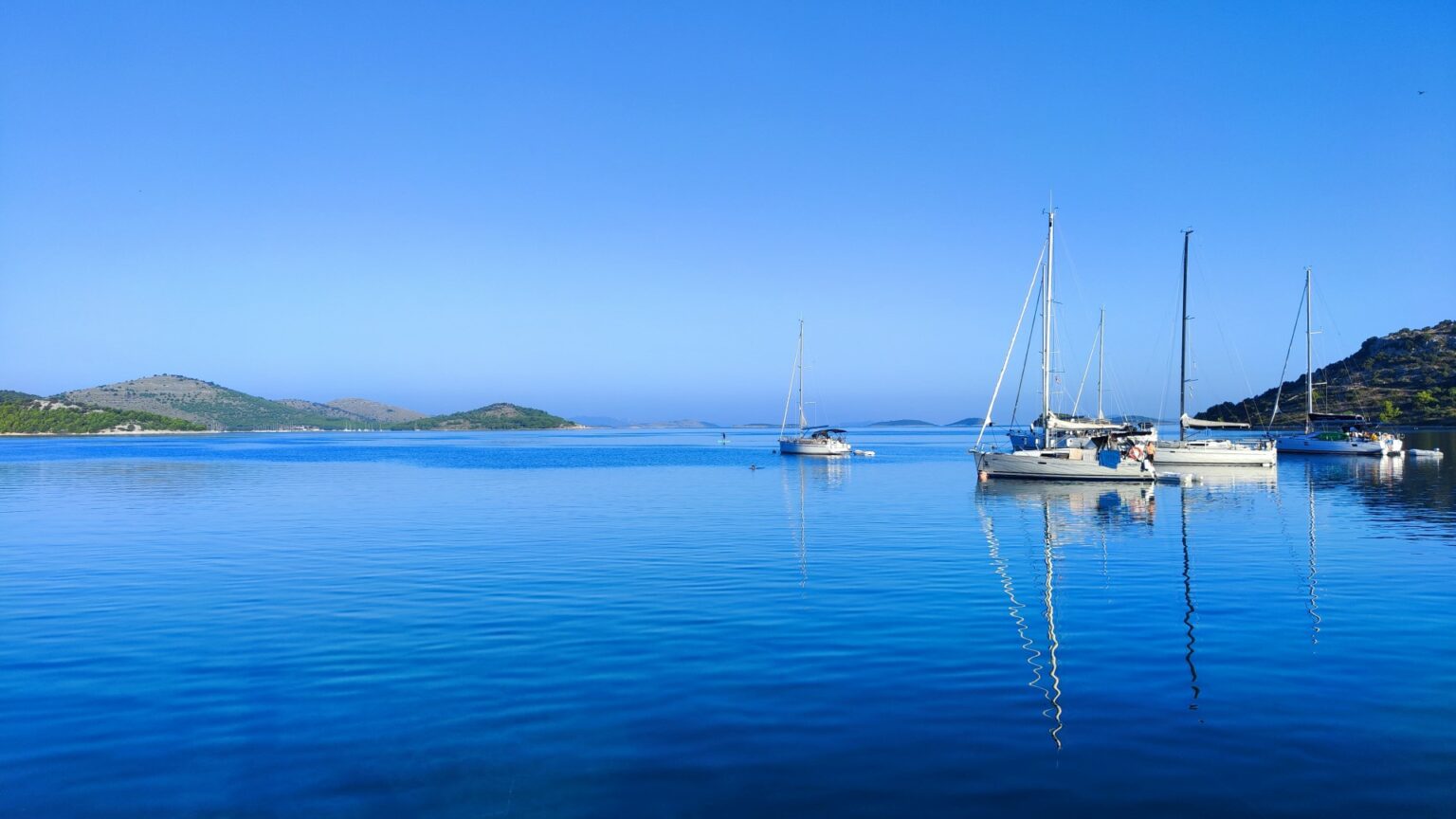 Jachty żaglowe stojące na kotwicy w chorwackiej zatoce.