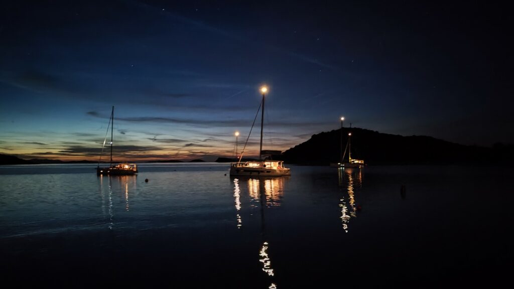 Jachty żaglowe stojące na kotwicy w zatoce w Chorwacji w gwieździstą noc