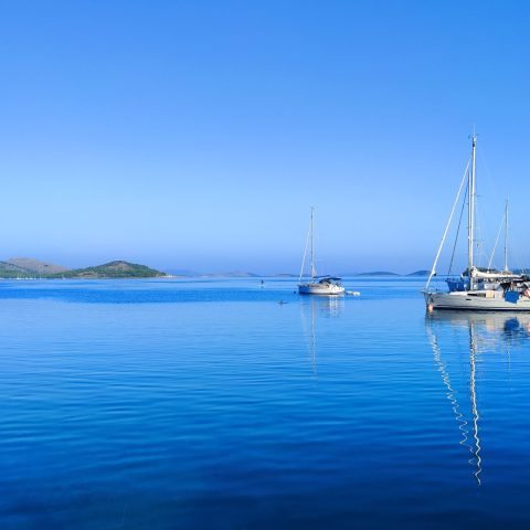 Jachty żaglowe stojące na kotwicy w chorwackiej zatoce.